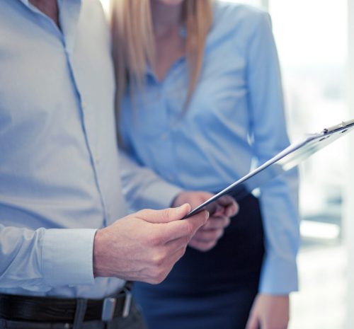 close up of business team looking at clipboard