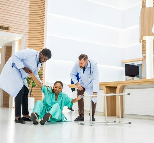 Group of people help female patient falling on the ground in hospital.