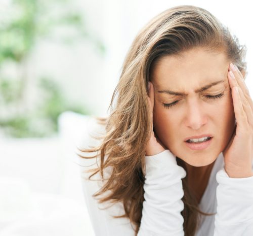 Young brunet woman with headache in the bed